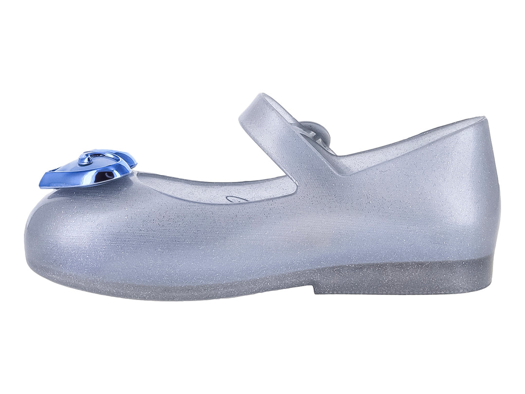 Zapato plateado con glitter para niña, correa ajustable y detalle de corazón azul en la punta.