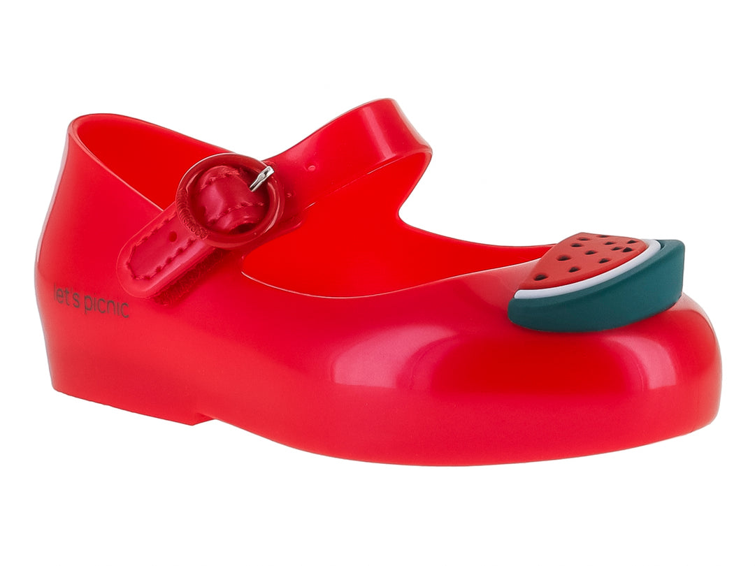 Zapato rojo brillante de plástico con correa y detalle de rebanada de sandía en la punta.