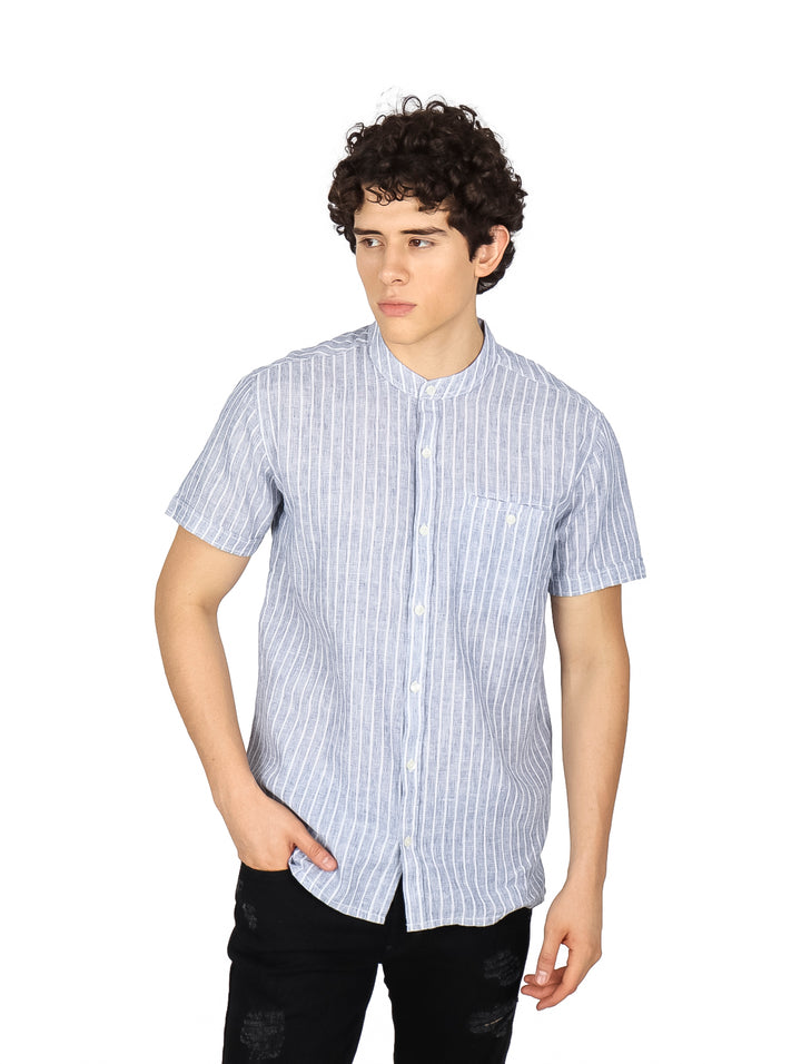 Hombre vistiendo una camisa de manga corta con rayas verticales azul marino y blanco.