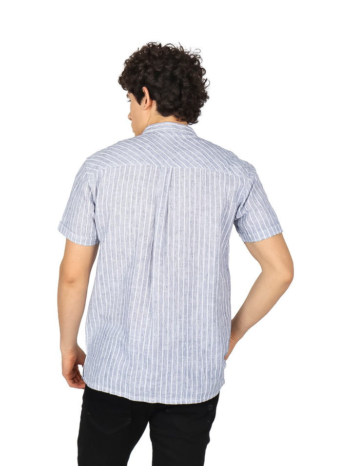 Hombre vistiendo una camisa de manga corta con rayas verticales azul marino y blanco.