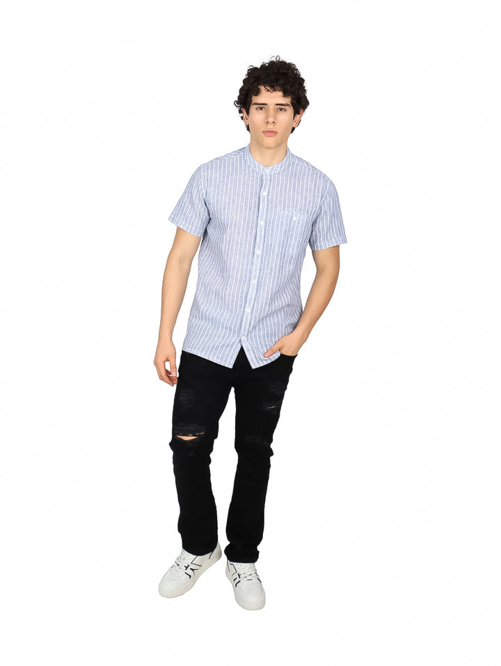 Hombre vistiendo una camisa de manga corta con rayas verticales azul marino y blanco.