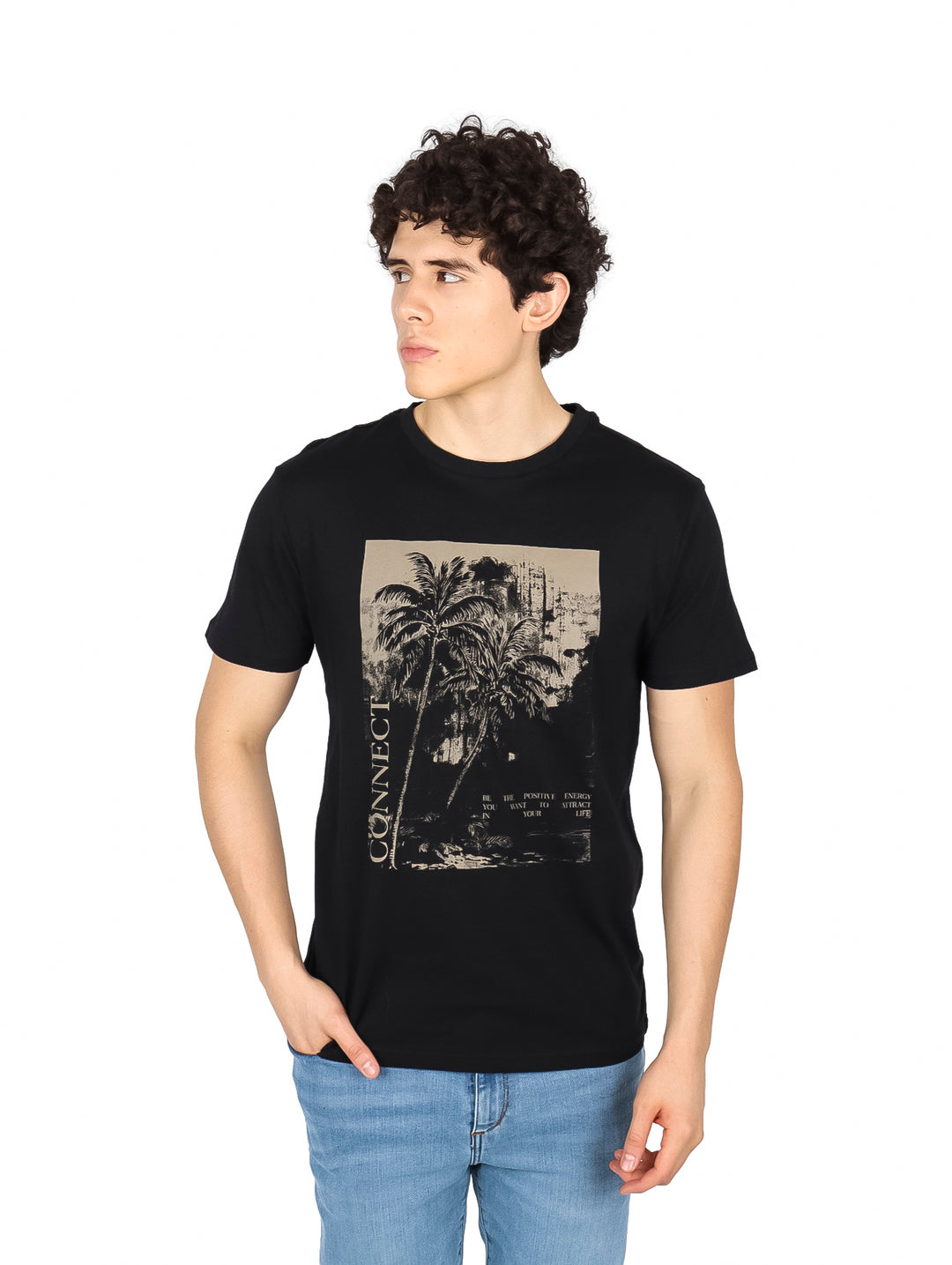 Hombre vistiendo una camiseta negra de manga corta con un estampado gráfico beige de palmeras en el pecho.