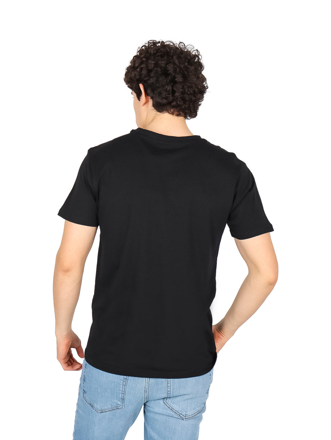 Hombre vistiendo una camiseta negra de manga corta con un estampado gráfico beige de palmeras en el pecho.