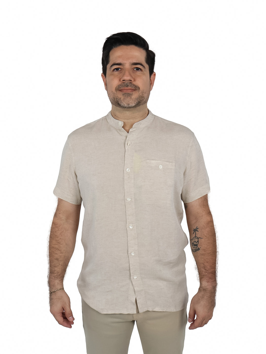 Hombre vistiendo una camisa de manga corta color beige con cuello mao y un bolsillo frontal.