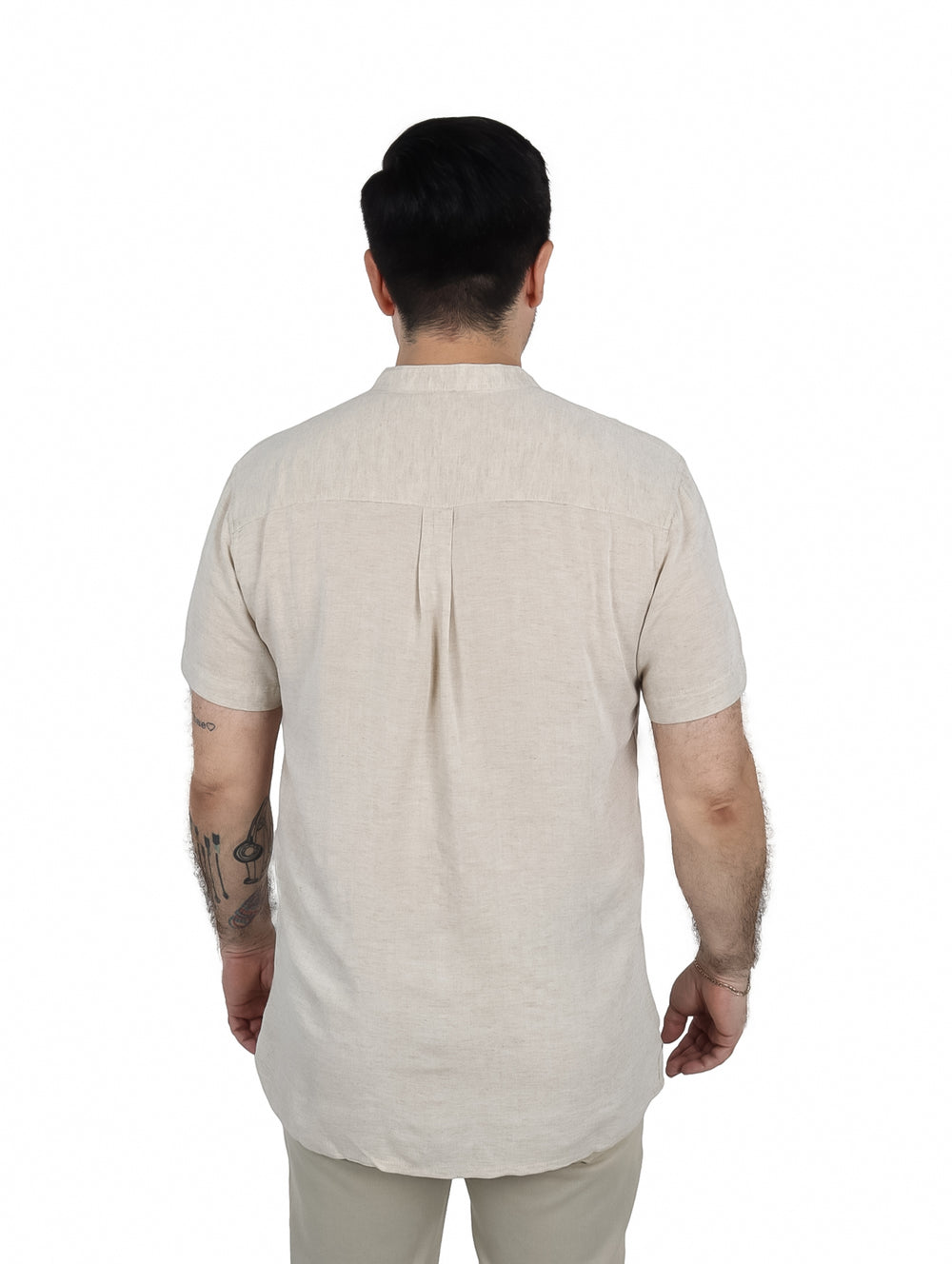 Hombre vistiendo una camisa de manga corta color beige con cuello mao y un bolsillo frontal.