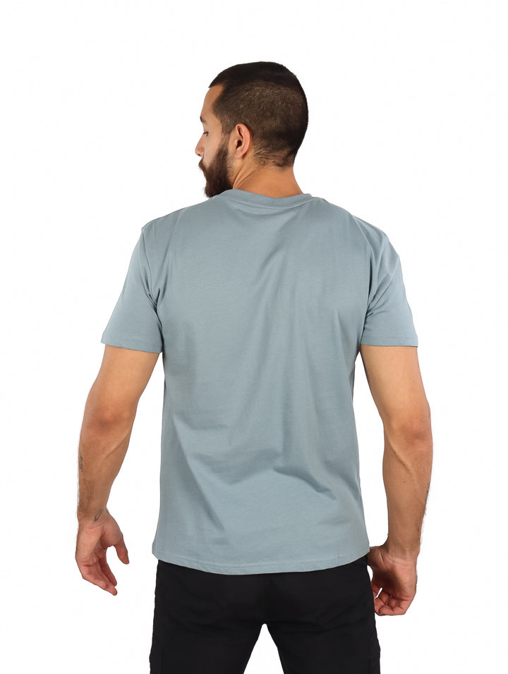 Camiseta gris de manga corta con estampado blanco de temática de surf.
