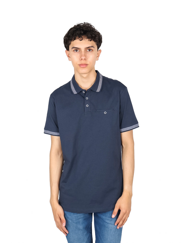 Hombre vistiendo una playera polo color azul marino con detalles de rayas blancas en cuello y mangas.