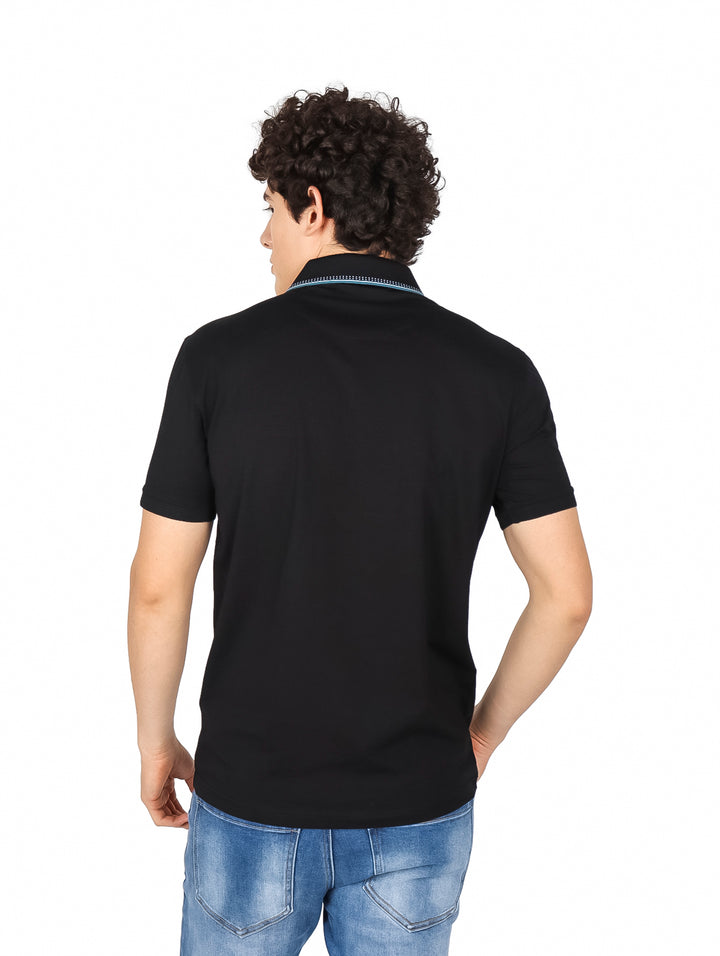 Hombre vistiendo playera polo color negro de manga corta con detalles azules en el cuello y pecho.