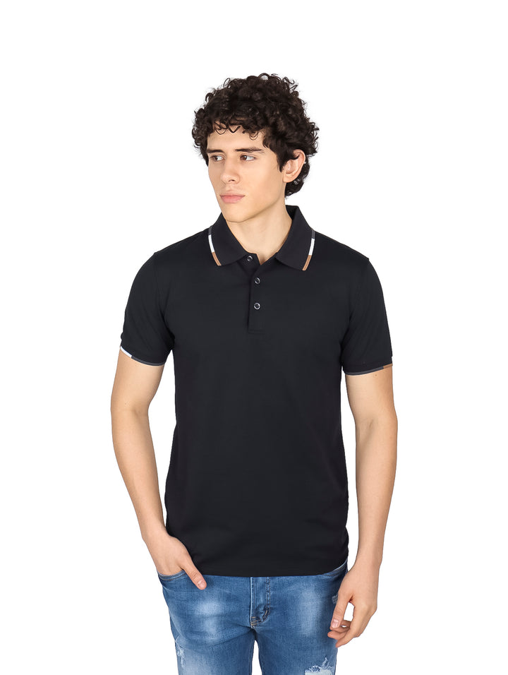 Hombre vistiendo una playera polo color negro con detalles en el cuello y mangas.