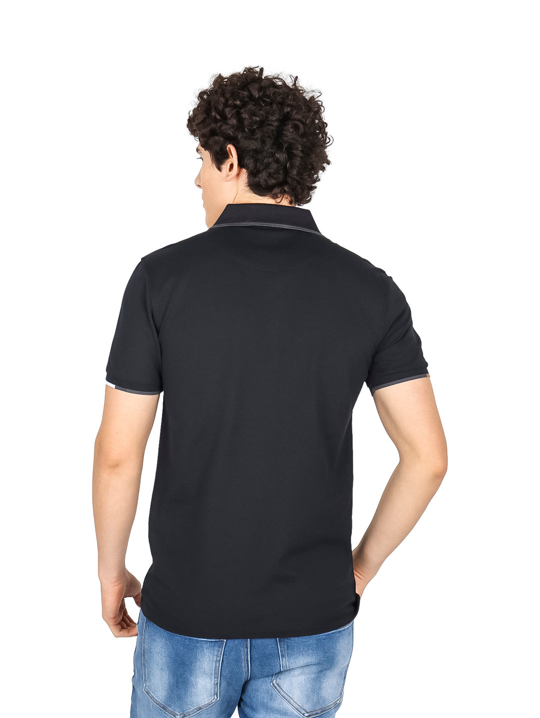 Hombre vistiendo una playera polo color negro con detalles en el cuello y mangas.