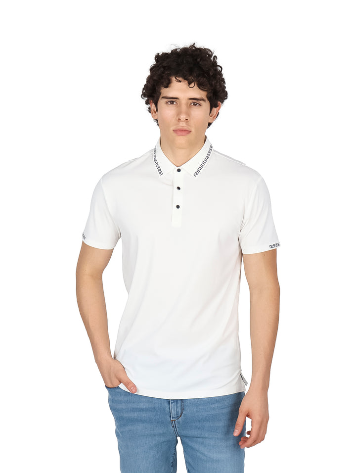 Hombre vistiendo una playera polo blanca de manga corta con detalles decorativos en el cuello y puños.