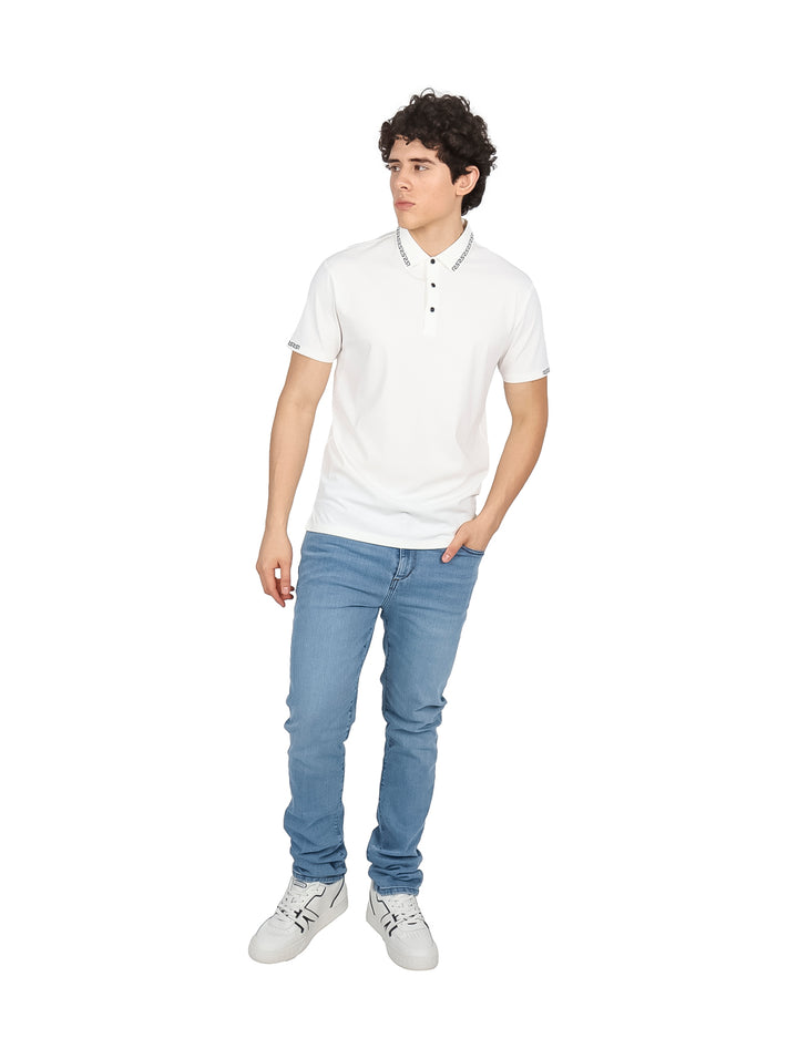 Hombre vistiendo una playera polo blanca de manga corta con detalles decorativos en el cuello y puños.