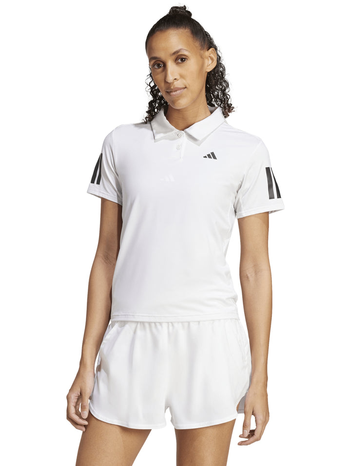 Mujer vistiendo conjunto deportivo Adidas blanco compuesto por playera polo y shorts de tenis.