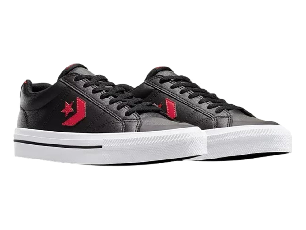 Tenis Converse negros de piel sintética con detalles en rojo y suela blanca.