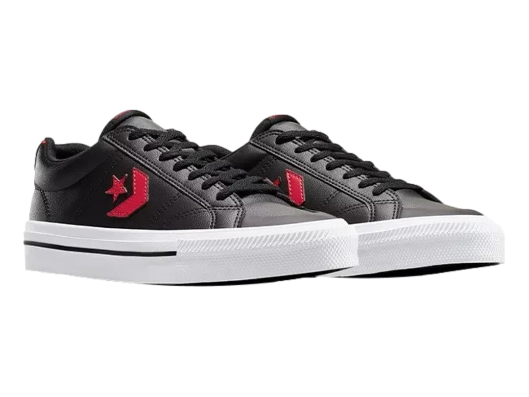 Tenis Converse negros de piel sintética con detalles en rojo y suela blanca.