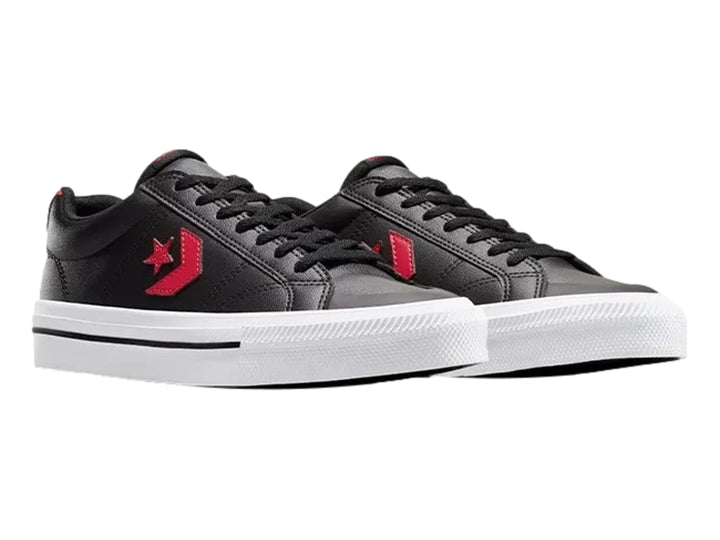 Tenis Converse negros de piel sintética con detalles en rojo y suela blanca.