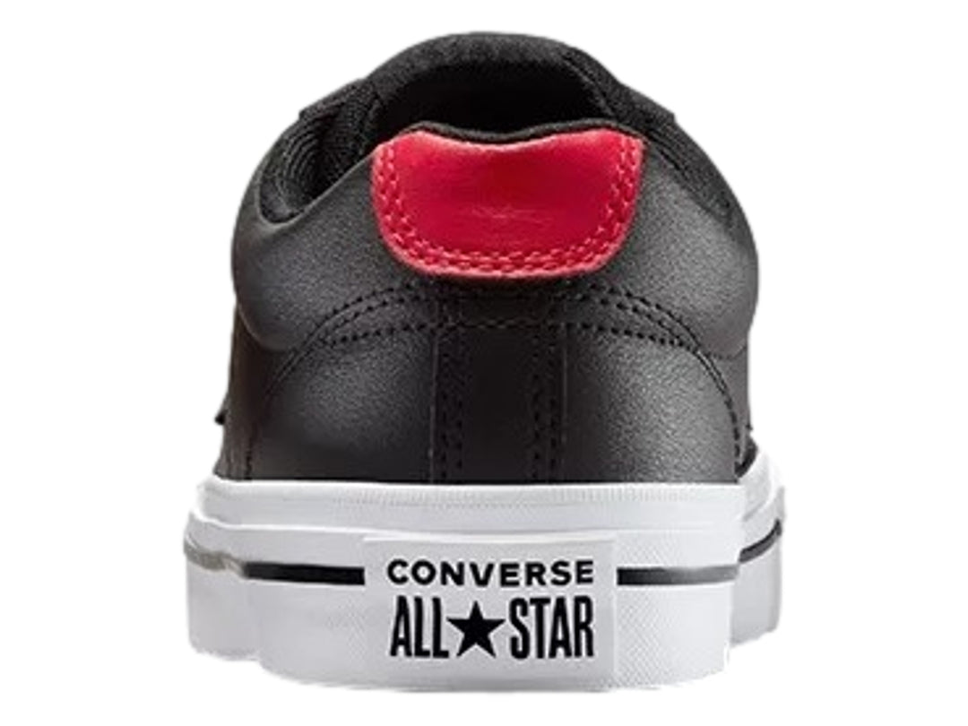 Tenis Converse negros de piel sintética con detalles en rojo y suela blanca.