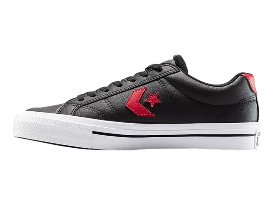 Tenis Converse negros de piel sintética con detalles en rojo y suela blanca.