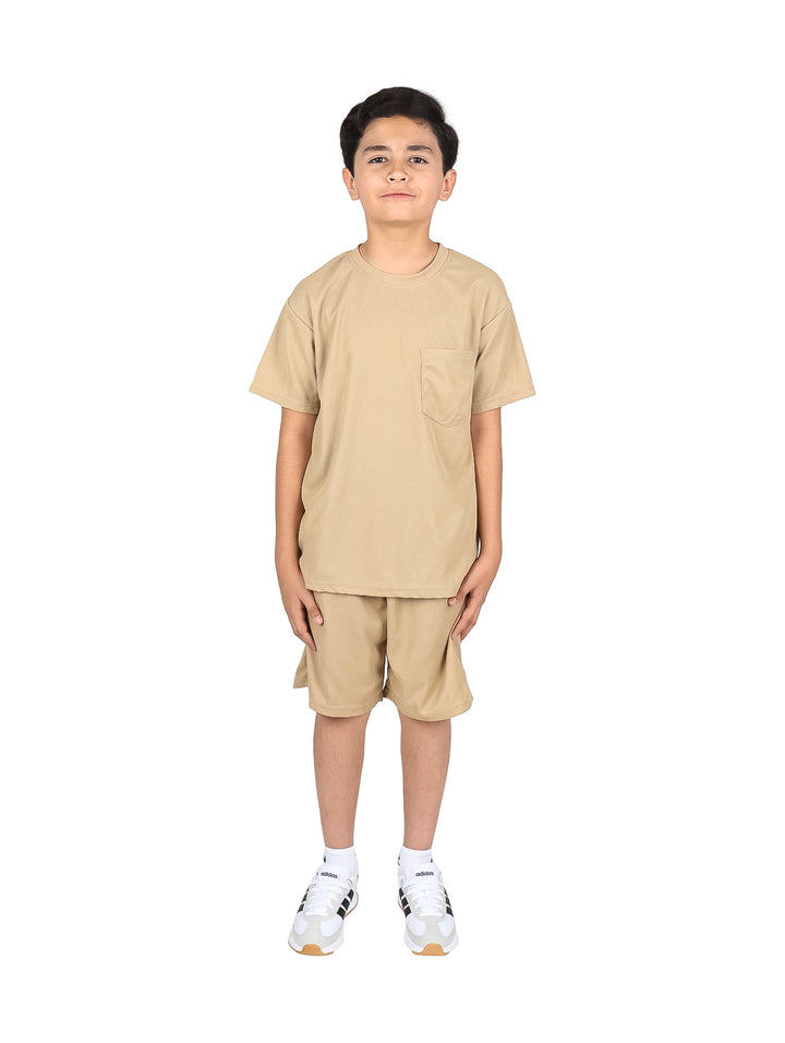 Niño vistiendo un conjunto de camiseta y short color beige.