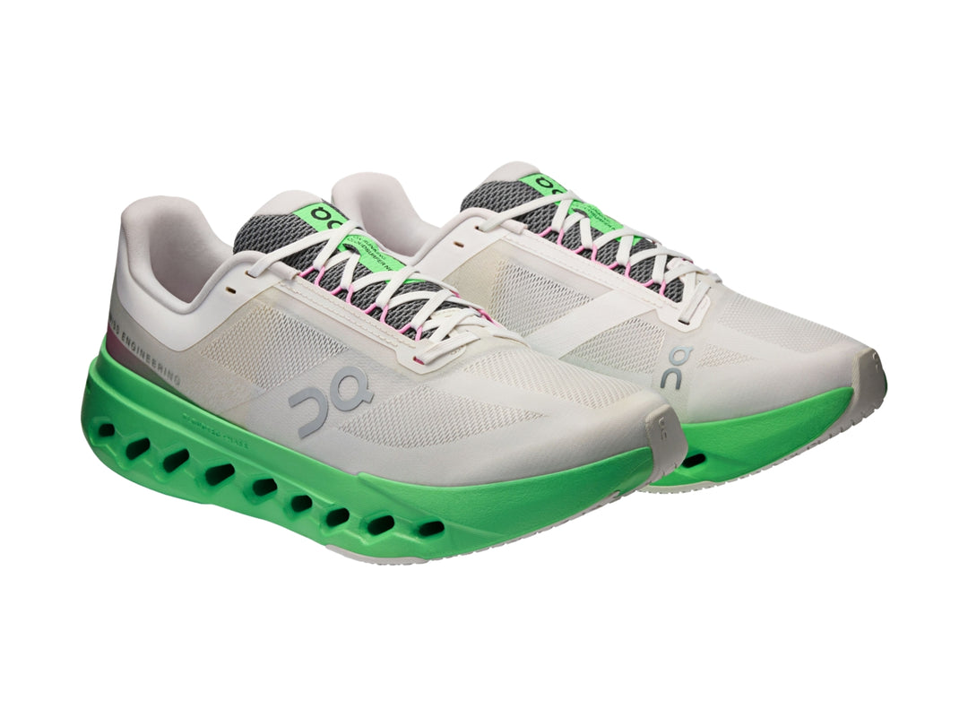 Tenis deportivos On Cloud color gris con suela verde brillante y detalles en rosa.