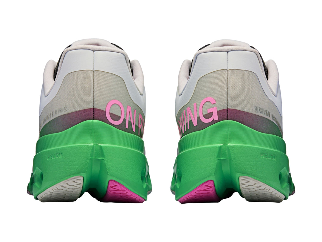 Tenis deportivos On Cloud color gris con suela verde brillante y detalles en rosa.