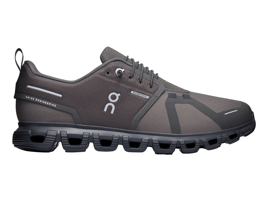 Tenis deportivos On Cloud color gris oscuro y negro con suela característica de cápsulas y tejido transpirable.