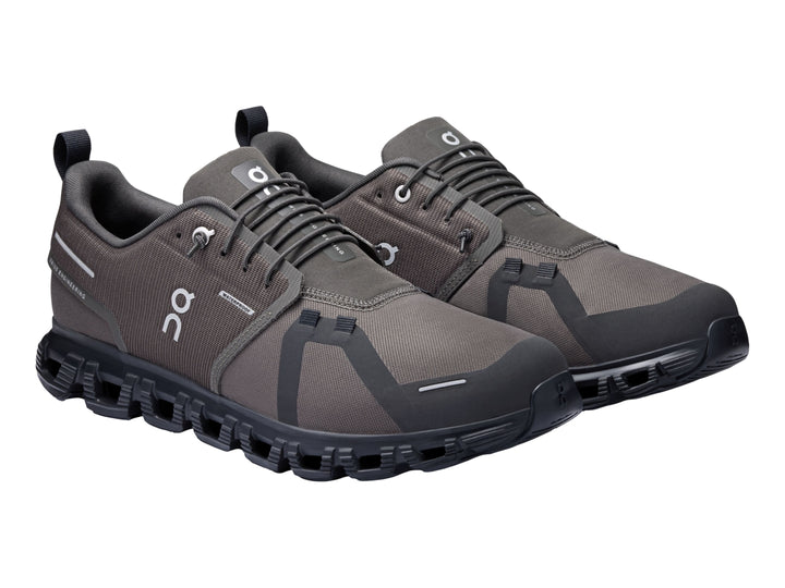 Tenis deportivos On Cloud color gris oscuro y negro con suela característica de cápsulas y tejido transpirable.