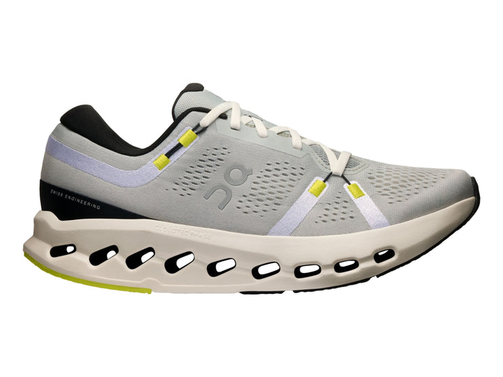 Tenis deportivos On Cloud Cloudsurfer 2 color gris glacier con suela marfil y detalles en amarillo neón.
