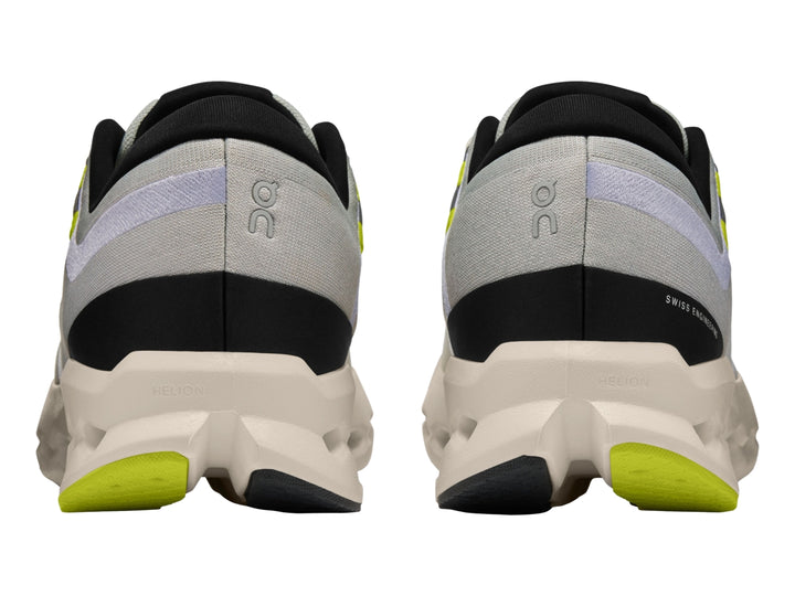 Tenis deportivos On Cloud Cloudsurfer 2 color gris glacier con suela marfil y detalles en amarillo neón.