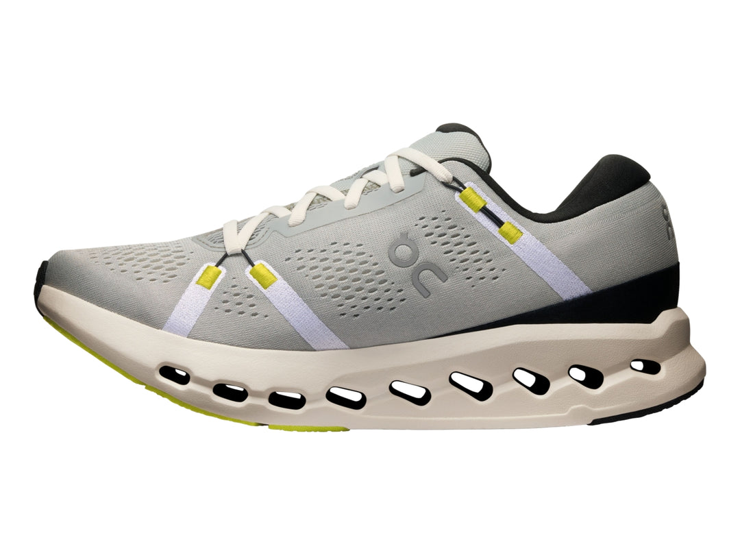 Tenis deportivos On Cloud Cloudsurfer 2 color gris glacier con suela marfil y detalles en amarillo neón.