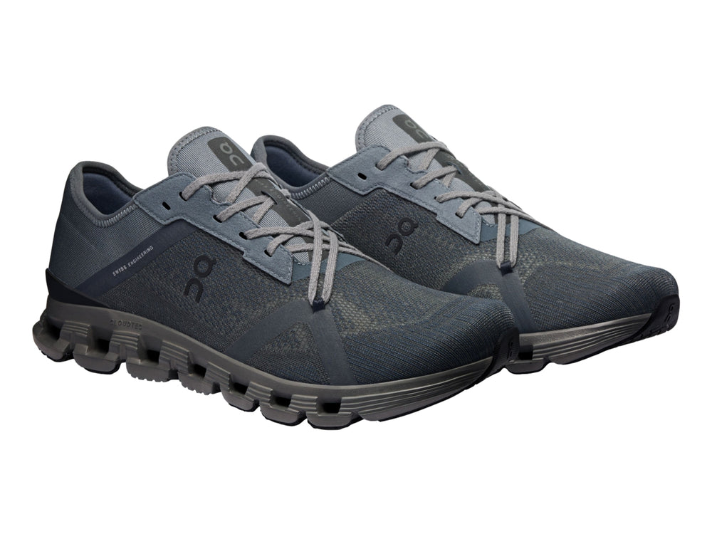 Tenis deportivos On Cloud X 4 AD en color negro y gris oscuro con suela segmentada característica.