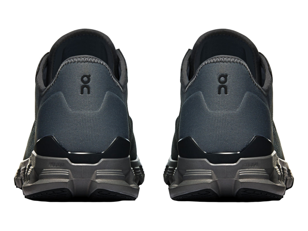 Tenis deportivos On Cloud X 4 AD en color negro y gris oscuro con suela segmentada característica.