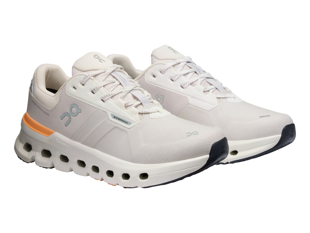 Tenis deportivos On Cloudrunner 2 WP color gris con detalles naranja y suela blanca con cavidades.