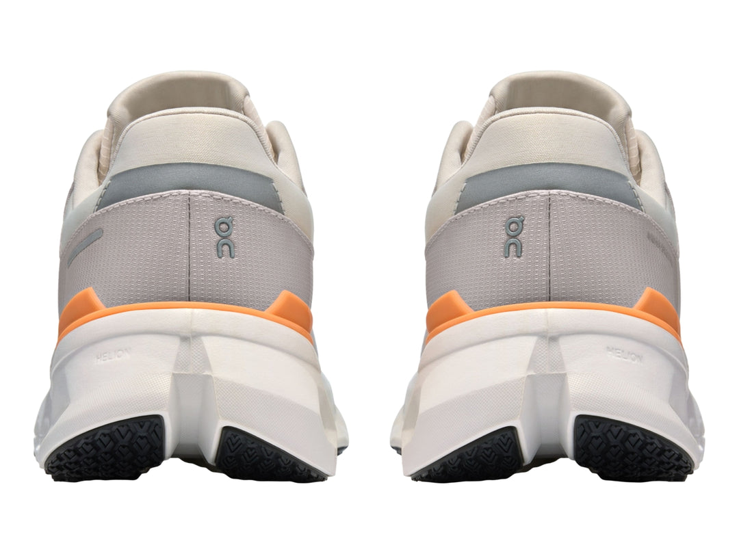 Tenis deportivos On Cloudrunner 2 WP color gris con detalles naranja y suela blanca con cavidades.