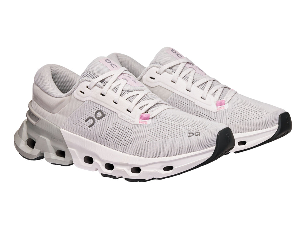 Tenis deportivos On Cloud color blanco y gris con suela tecnológica y detalles en rosa.