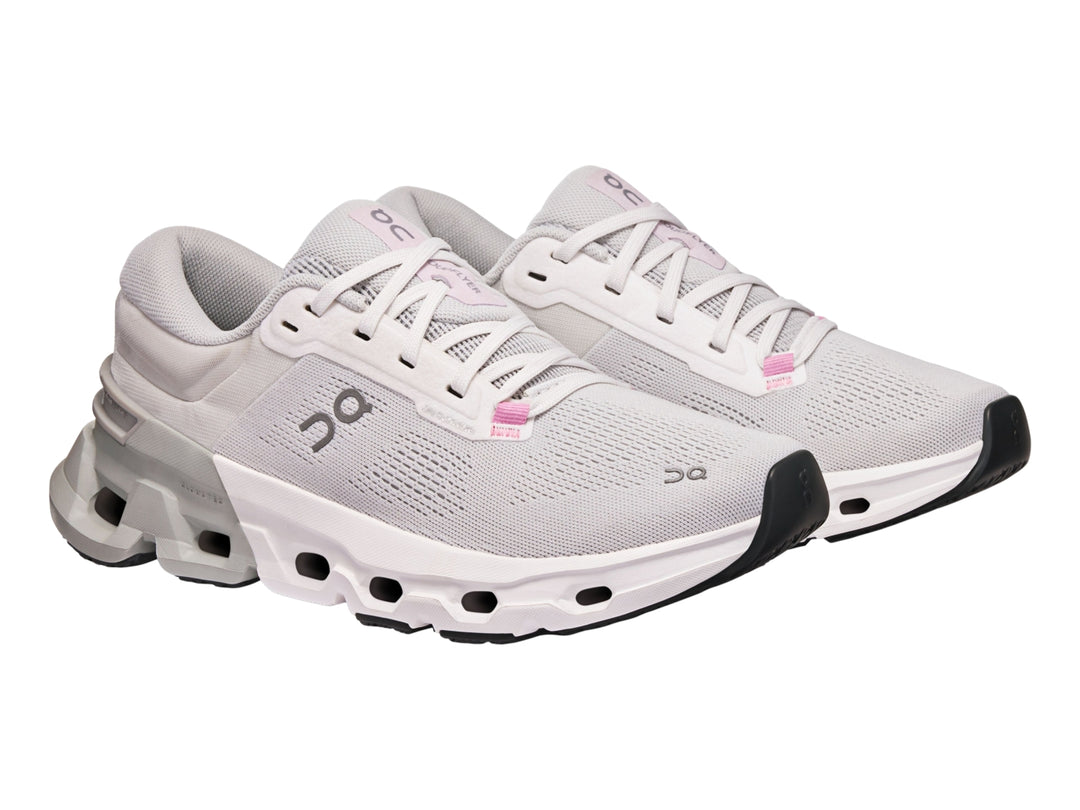 Tenis deportivos On Cloud color blanco y gris con suela tecnológica y detalles en rosa.