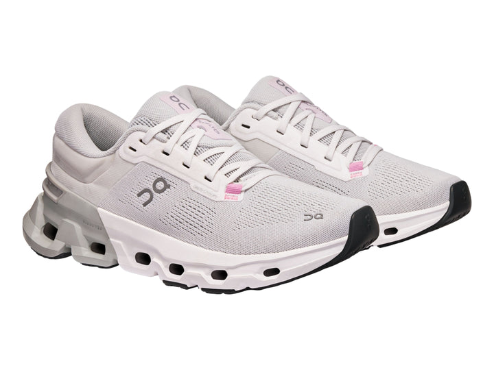 Tenis deportivos On Cloud color blanco y gris con suela tecnológica y detalles en rosa.