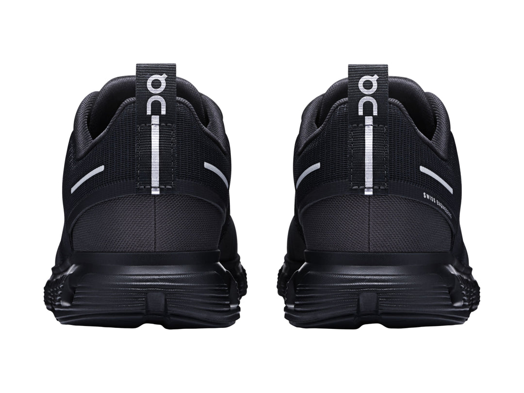 Tenis deportivos On Cloud color negro con suela amortiguada característica y detalles en blanco.