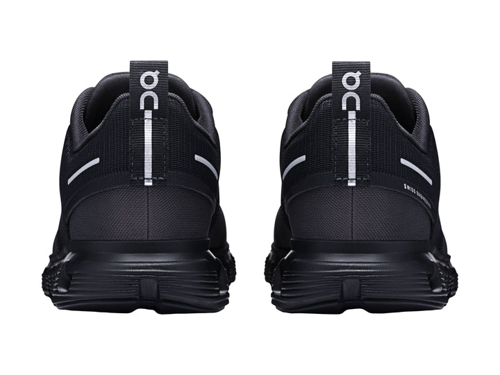 Tenis deportivos On Cloud color negro con suela amortiguada característica y detalles en blanco.