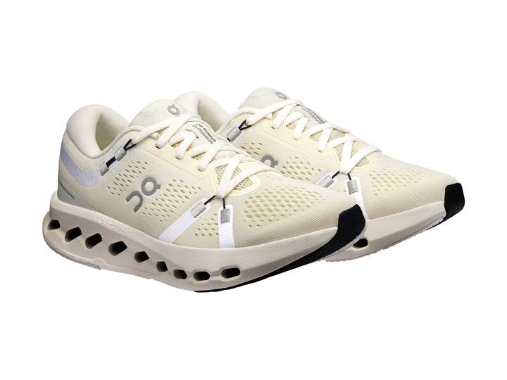 Tenis deportivos On Cloud color marfil con suela blanca perforada y detalles en gris.
