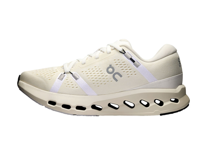 Tenis deportivos On Cloud color marfil con suela blanca perforada y detalles en gris.