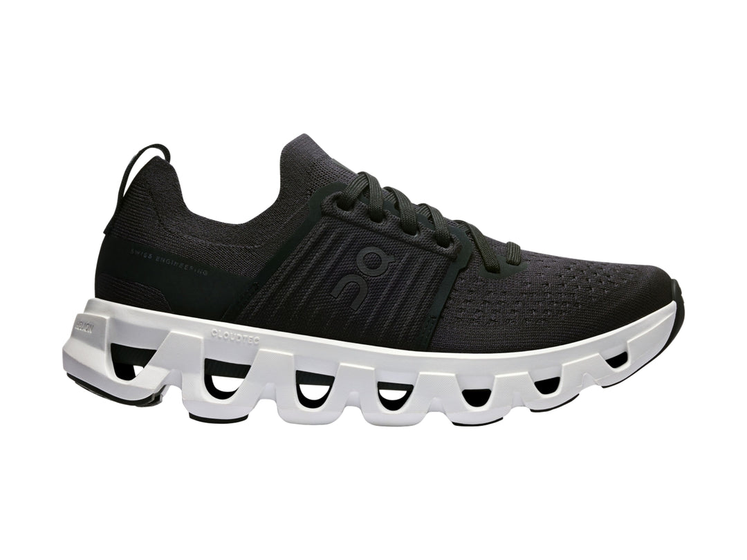 Tenis deportivos On Cloud color negro con suela blanca robusta y diseño moderno.