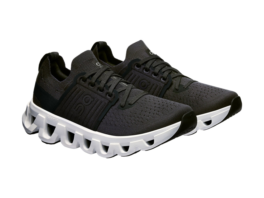 Tenis deportivos On Cloud color negro con suela blanca robusta y diseño moderno.