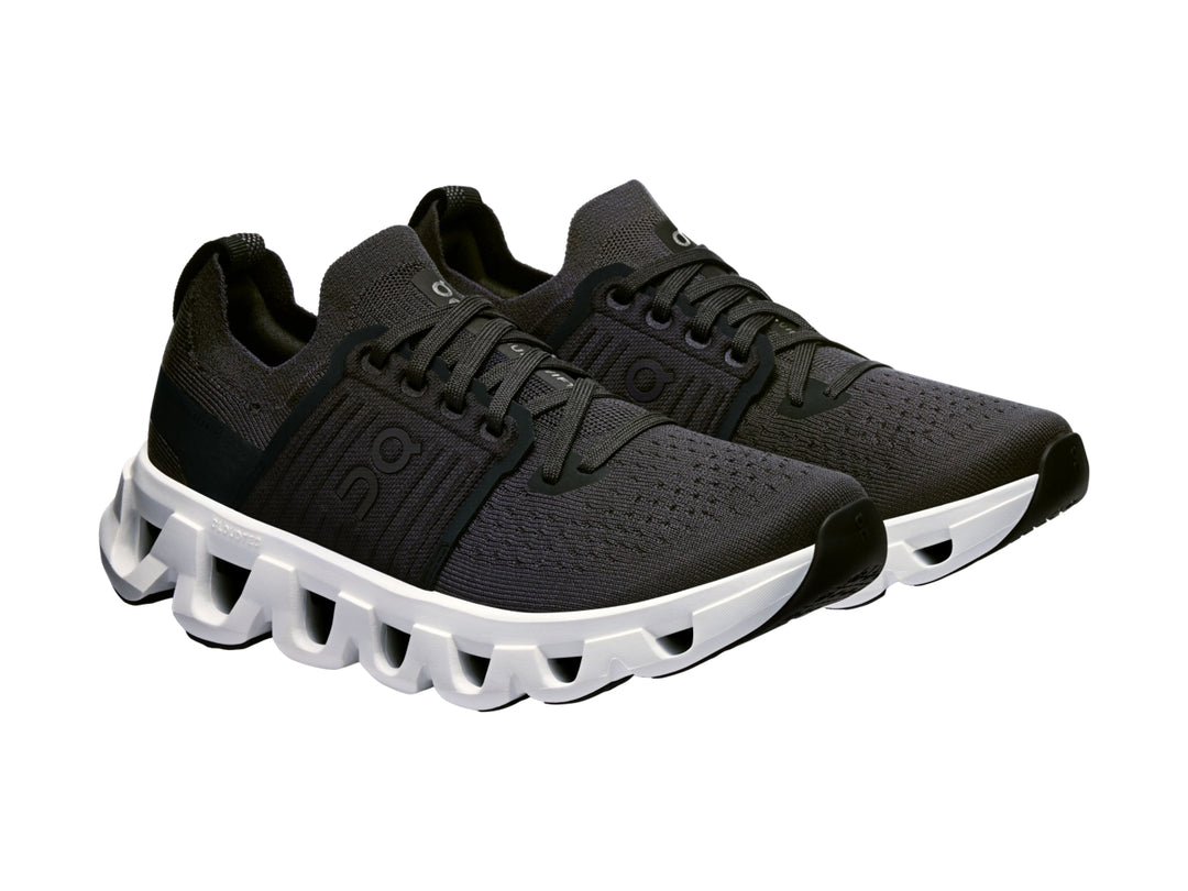 Tenis deportivos On Cloud color negro con suela blanca robusta y diseño moderno.
