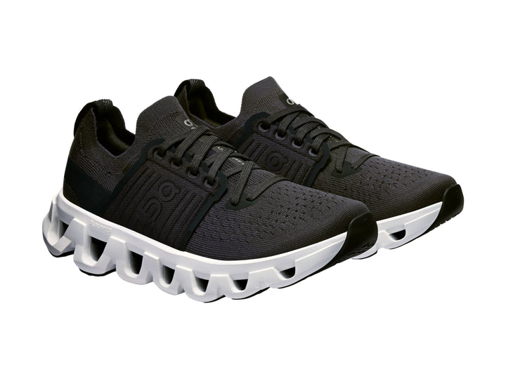 Tenis deportivos On Cloud color negro con suela blanca robusta y diseño moderno.