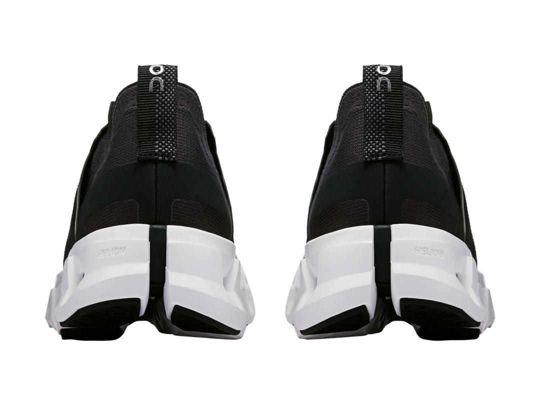 Tenis deportivos On Cloud color negro con suela blanca robusta y diseño moderno.