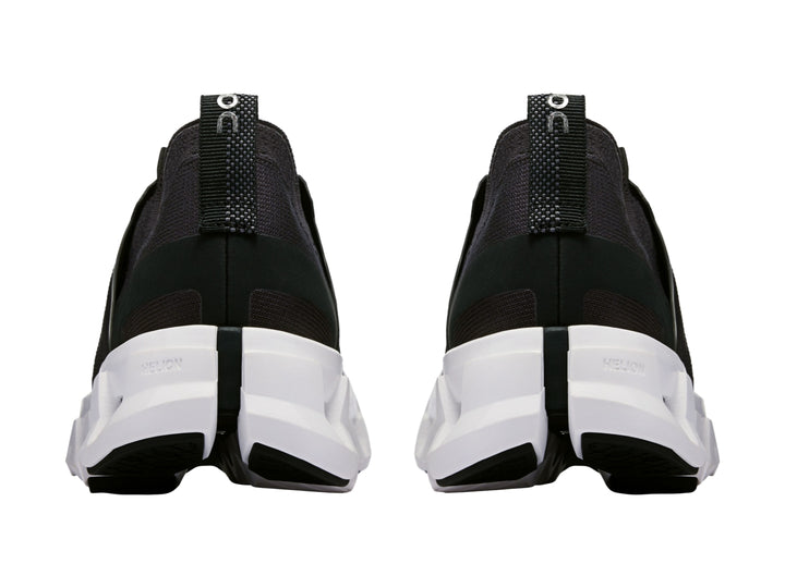 Tenis deportivos On Cloud color negro con suela blanca robusta y diseño moderno.