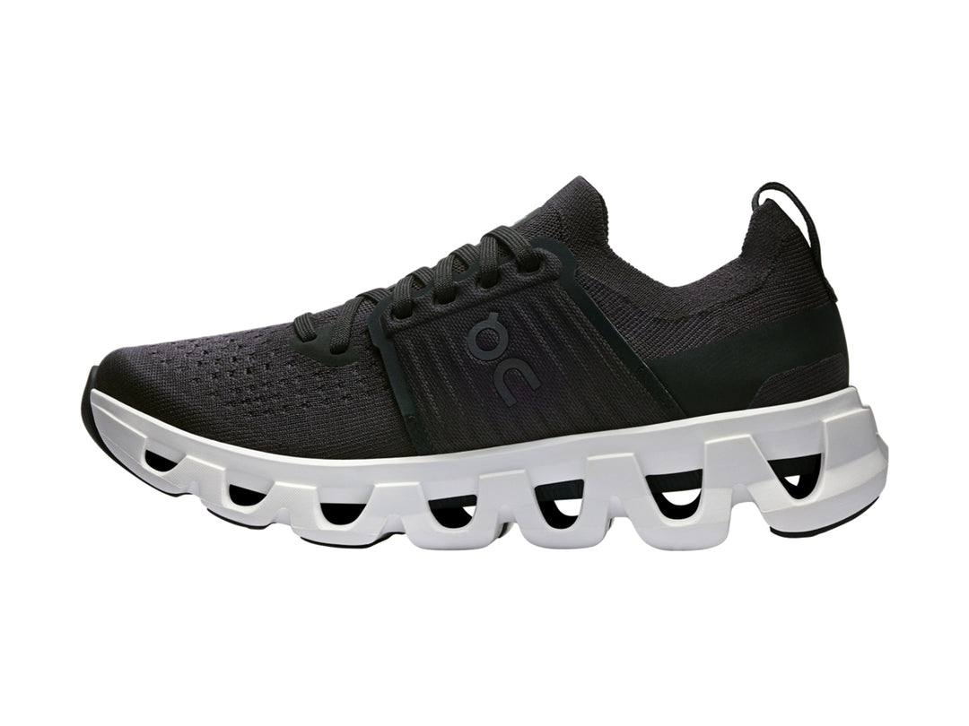 Tenis deportivos On Cloud color negro con suela blanca robusta y diseño moderno.