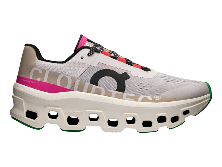 Tenis deportivos On Cloudmonster en color plata y marfil con detalles en rosa y negro.