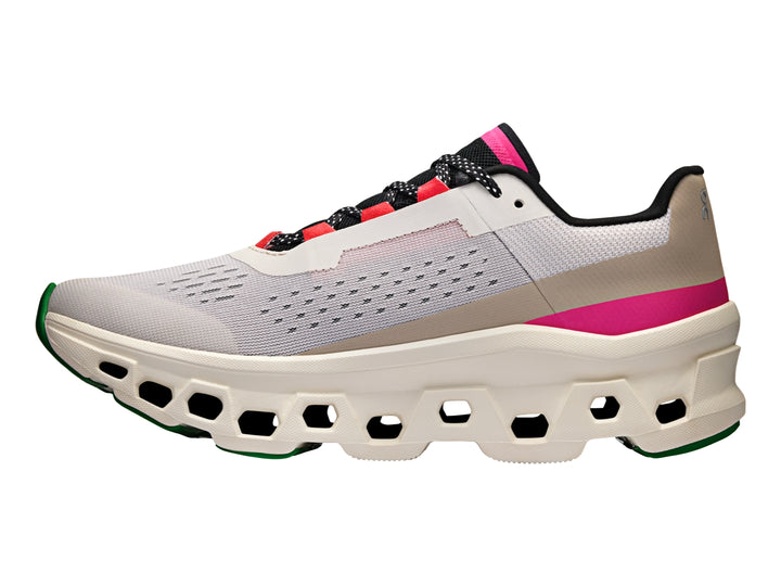Tenis deportivos On Cloudmonster en color plata y marfil con detalles en rosa y negro.